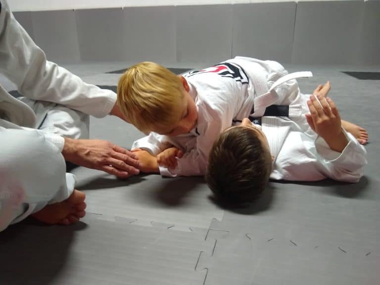 Two children practicing Brazilian Jiu Jitsu technique