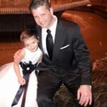 Man in black suit next to little girl